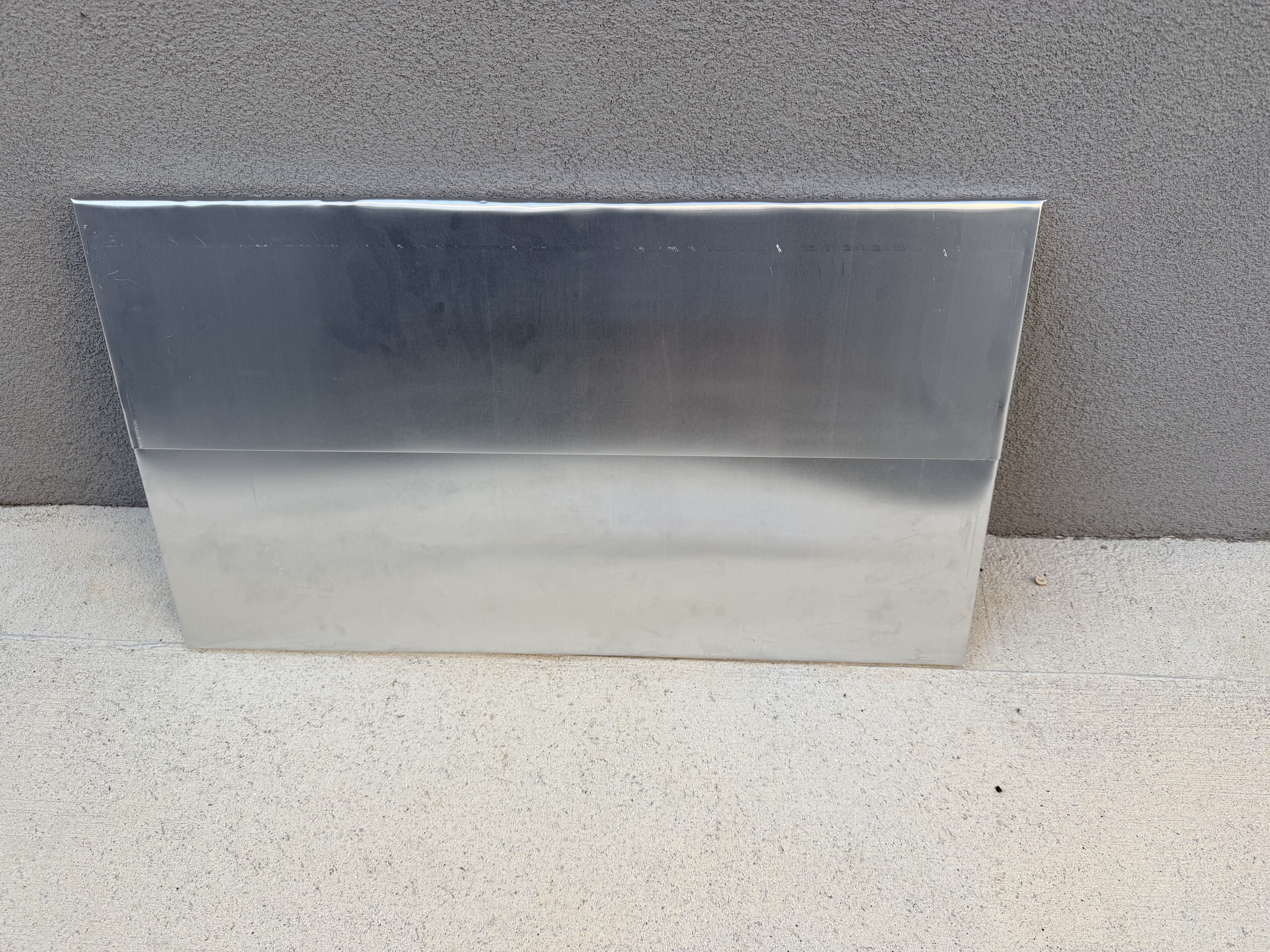 Roof panel clad in two overlapping sheets of aluminium, folded over the edges